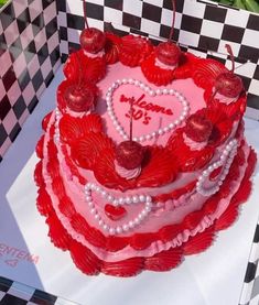 a heart shaped cake with red icing and hearts on it