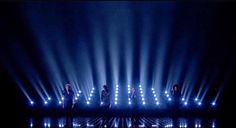 the backs performing on stage with blue lights