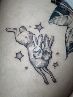 a woman's stomach with an image of two rabbits flying through the air and stars