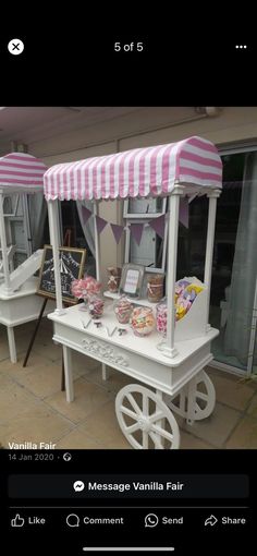 a white cart with pink and white striped awning