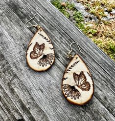 Beautiful butterfly and floral earrings for nature lovers. Natural wood earrings. All earrings have been hand painted or wood burned. Earrings are done freehand so each set is unique!  Eco friendly and a wonderful way to dress up an outfit with natural jewelry.  Earrings are lightweight with hypoallergenic hooks. 2 inches in length  Much of my work are custom requests from people wanting one of a kind jewelry.  Order now for yourself or someone else! Wood Burning Earring Ideas, Wood Burned Earrings, Wood Jewelery, Engraving Ideas, Wood Dangle Earrings, Earrings Wood, Natural Jewelry, Earrings Teardrop, Wood Work