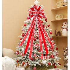 a decorated christmas tree with red and white ribbons