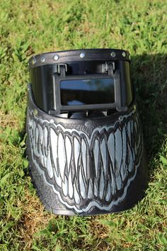 a black and white helmet sitting on top of green grass