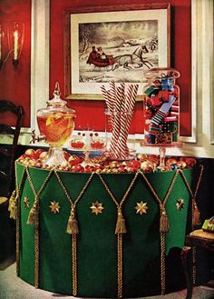 a green table topped with candy canes and candies next to a painting on the wall