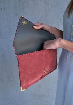 a woman holding a red and black purse