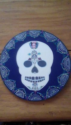 a blue and white plate with a skull on it's side sitting on a wooden table