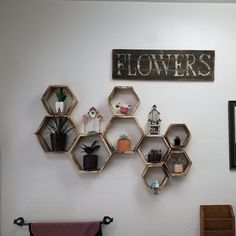 several hexagonal shelves are on the wall above a chair and other decorative items