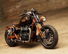 an orange and black motorcycle parked in a garage