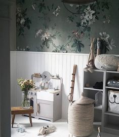 a child's room with floral wallpaper and furniture