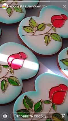 several decorated cookies in the shape of hearts with roses and leaves on them are shown