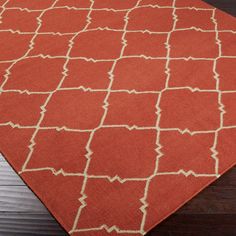 a red and white rug on top of a wooden floor