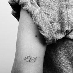 a person with a small tattoo on their arm and the number 46 tattooed on it