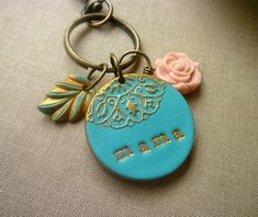 a close up of a keychain with a flower and name on the front