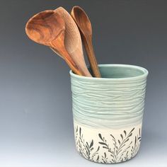 two wooden spoons in a ceramic cup