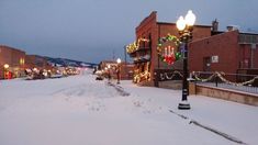 the street is covered in snow and decorated with christmas lights, garlands and decorations