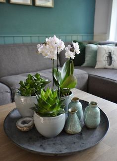 there is a tray with some flowers on it and two vases sitting next to each other