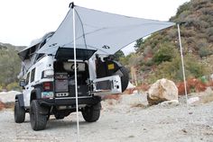 an off road camper is parked in the desert with its tent attached to it's roof