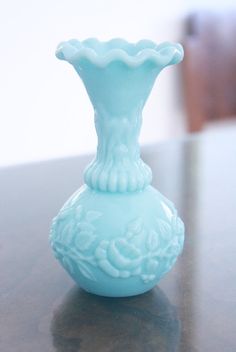 a blue vase sitting on top of a wooden table