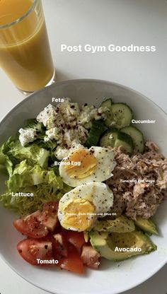 a white plate topped with lots of food next to a glass filled with orange juice