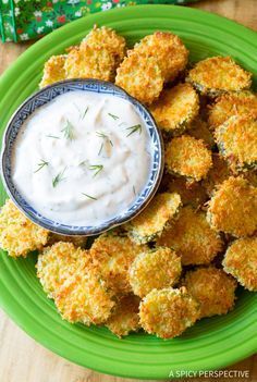 a green plate topped with tater tots and ranch dip