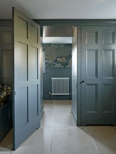 an open door leading to another room with blue walls and white tile on the floor