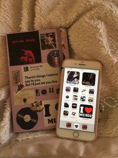 an ipod sitting on top of a bed next to a book and mp3 player in front of it