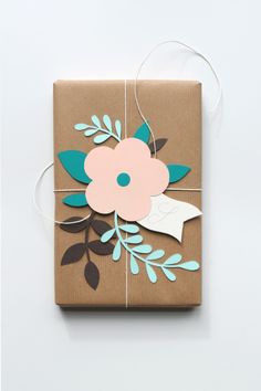 a gift wrapped in brown paper with blue and pink flowers