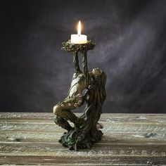 a candle that is sitting on top of a tree stump with its hands in the air