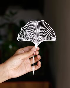 a hand holding a paper fan in the air