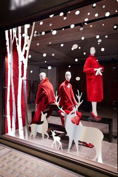 two mannequins dressed as santa claus and reindeer in front of a store window