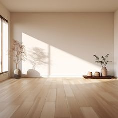 an empty room with wooden floors and potted plants on the floor, in front of large windows