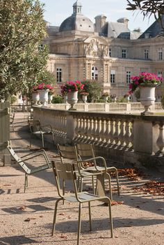 there are many empty chairs on the side of this walkway in front of an old building