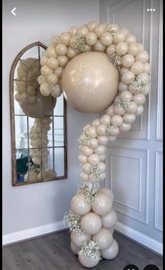 a balloon arch is decorated with white balloons