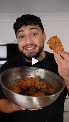 a man holding a metal bowl filled with food