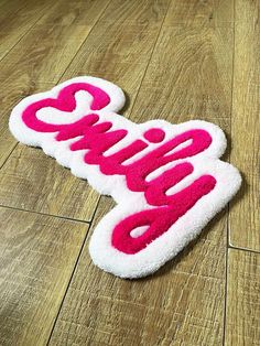 a white and pink rug with the word candy written in red on top of it