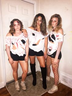 three young women dressed up in costumes posing for a photo with one woman wearing fishnet stockings and the other holding a t - shirt