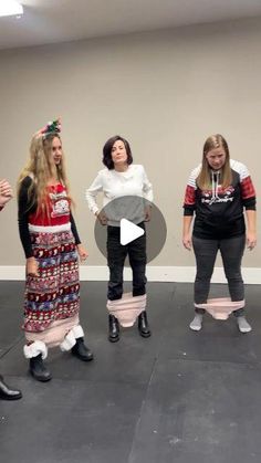 four women in dresses are standing on the floor and one woman is wearing black boots