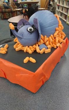 an orange table topped with lots of corn kernels next to a blue and black object