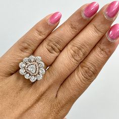 a woman's hand with pink manicured nails and a diamond ring