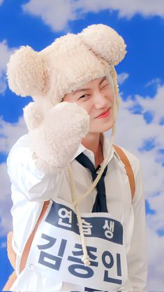 a young man wearing a white shirt and tie with a teddy bear hat on his head