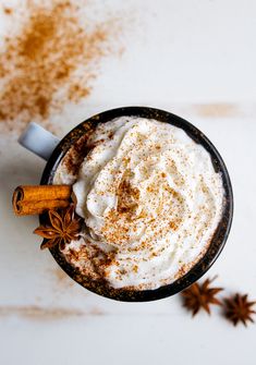 a cup of hot chocolate with whipped cream and cinnamon sprinkles on top