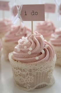 cupcakes with pink frosting and white polka dots are on top of each other