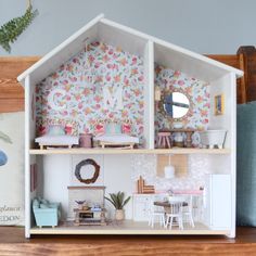 a doll house with furniture and accessories on the shelf in front of it is decorated