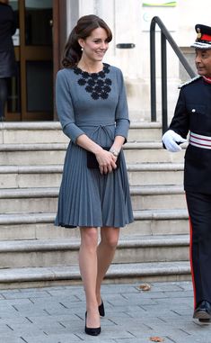 the duke and princess of cambridge are smiling as they stand on steps in front of an official guard