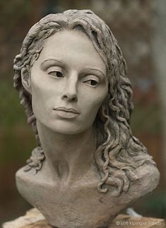 a statue of a woman's head with braids on her hair is shown