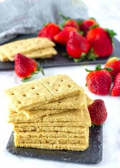 crackers stacked on top of each other with strawberries next to them in the background