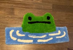 a rug with a green frog sitting on top of it