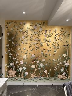 a bathroom with a gold wall and flowers on it