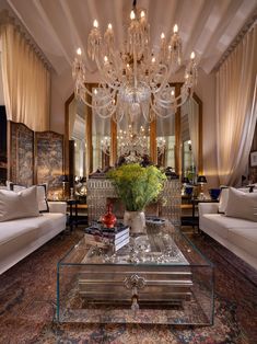 a living room filled with furniture and a large chandelier hanging from the ceiling