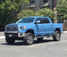 a blue truck is parked in a parking lot